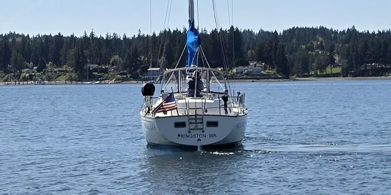 Slide: The Image of Sailboat on calm water, Pearson 385 model, 1985, near Kingston, WA, with forested shoreline. - 1