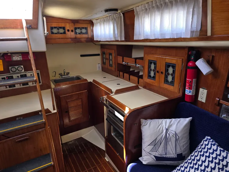 Slide: The Image of Interior of a 1985 Pearson 385 sailboat featuring a cozy kitchen and seating area. - 15