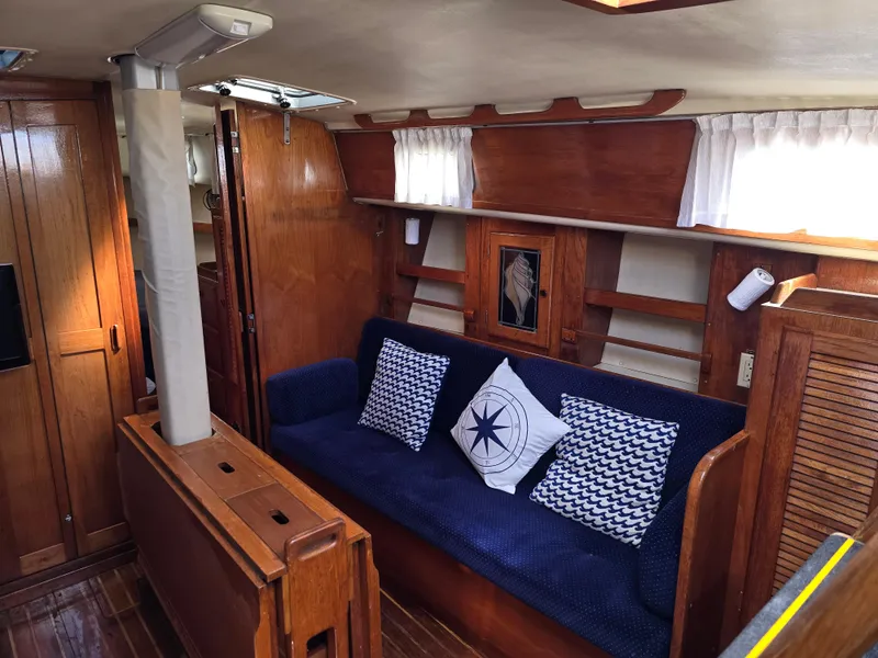 Slide: The Image of Interior of 1985 Pearson 385 sailboat with wooden furnishings and nautical-themed cushions. - 17