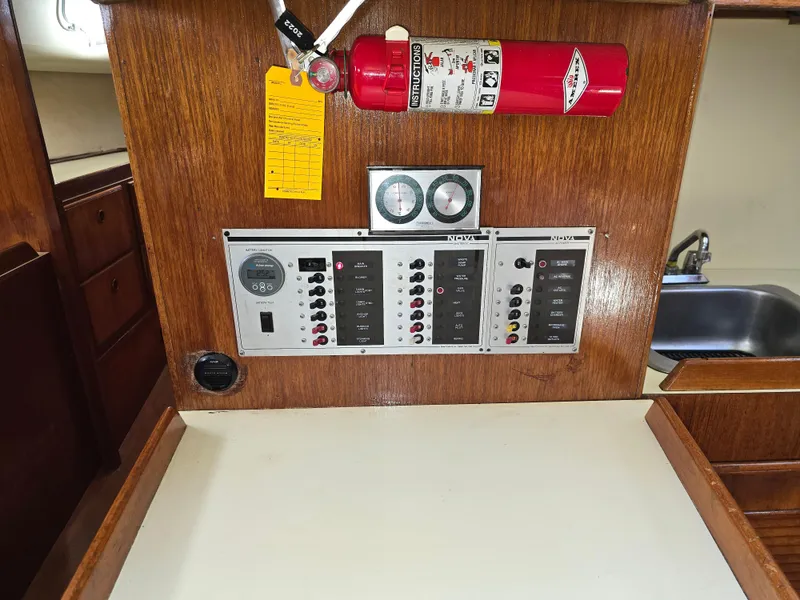 Slide: The Image of Control panel of a 1985 Pearson 385 sailboat with fire extinguisher and gauges. - 23