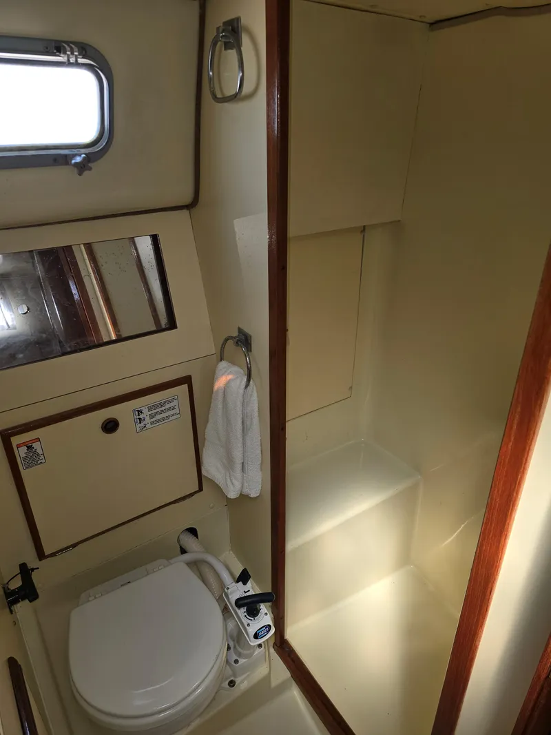 Slide: The Image of 1985 Pearson 385 yacht bathroom with toilet, towel, and window. - 27