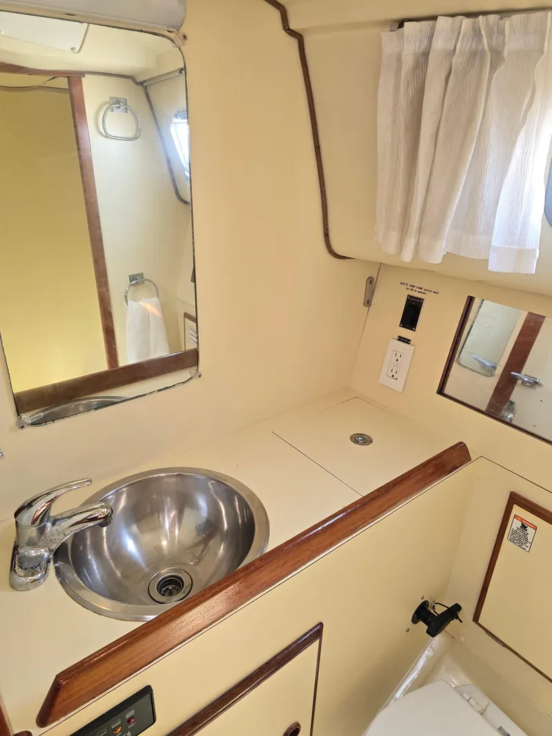 Slide: The Image of 1985 Pearson 385 yacht bathroom with sink, mirror, and curtain. - 28