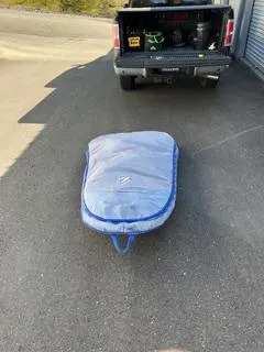 Slide: The Image of Surfboard in blue cover on pavement near truck, Pearson 385, 1985 model. - 29