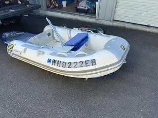 Slide: The Image of 1985 Pearson 385 inflatable boat with registration number, parked on pavement. - 32