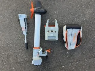 Slide: The Image of Electric boat motor components on pavement, featuring propeller and control unit, Pearson 385, 1985 model. - 35