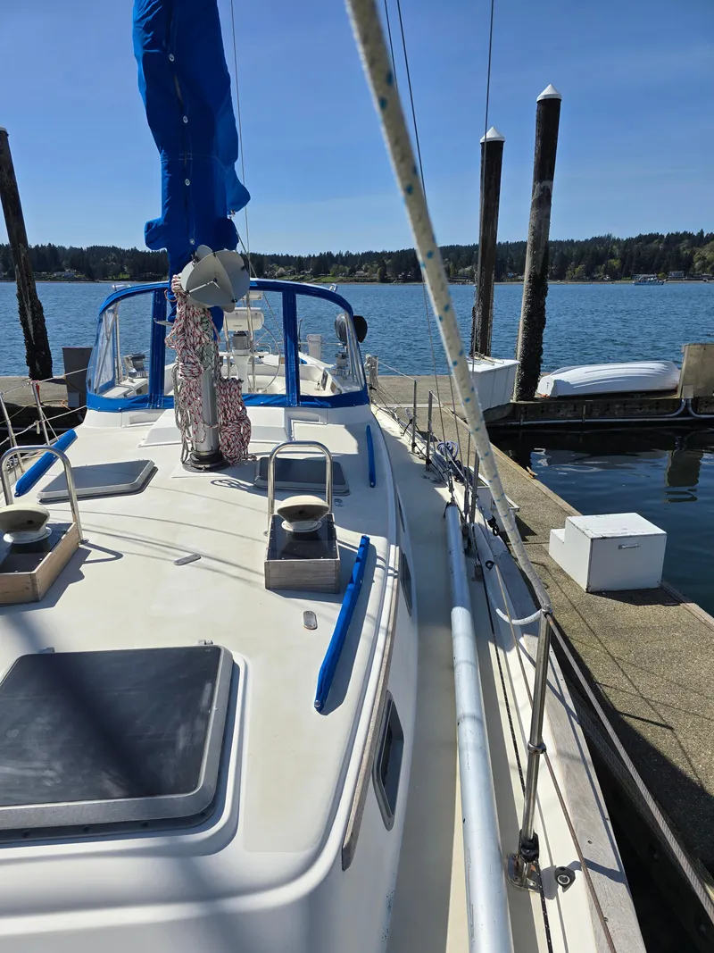 Slide: The Image of 1985 Pearson 385 sailboat docked at a marina, clear blue sky and water. - 5