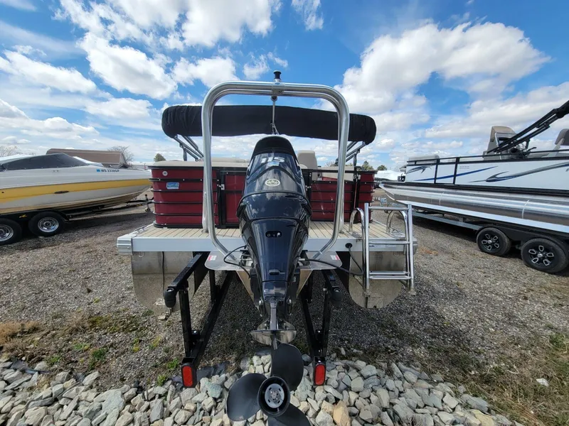 Slide: The Image of 2021 Landau 220 Atlantis pontoon boat with outboard motor, parked on gravel lot. - 3