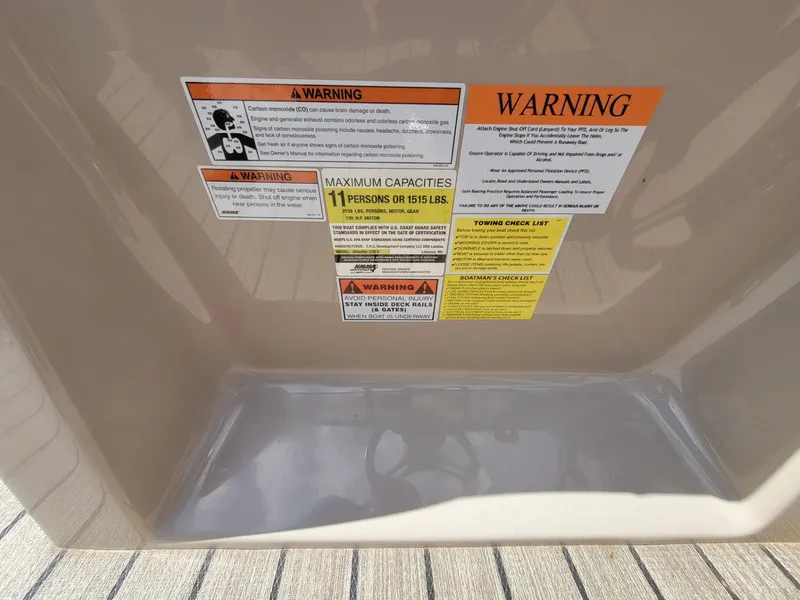 Slide: The Image of Warning labels on 2021 Landau 220 Atlantis boat, detailing safety and capacity information. - 30
