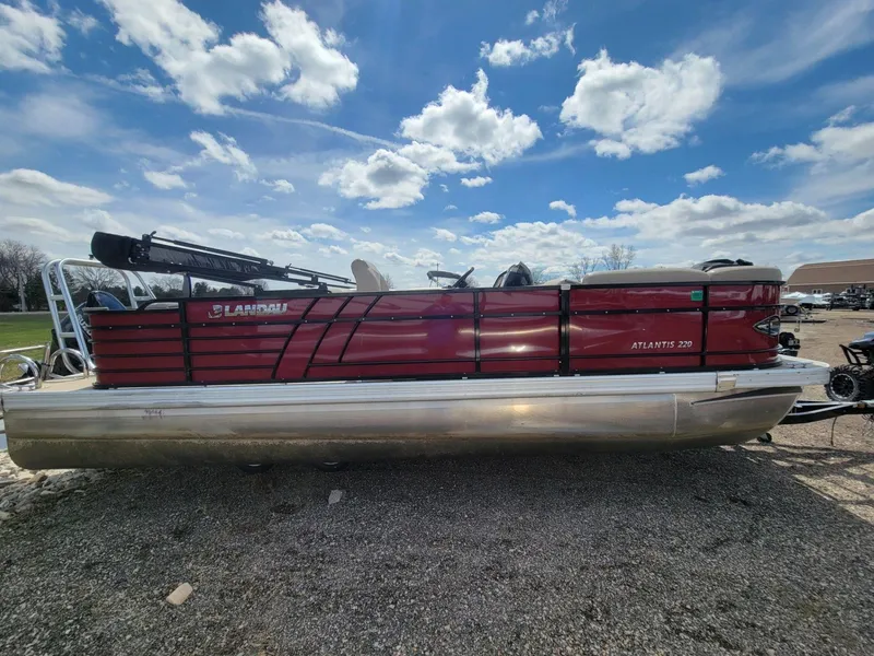 Slide: The Image of 2021 Landau 220 Atlantis pontoon boat with red exterior under a blue sky. - 5