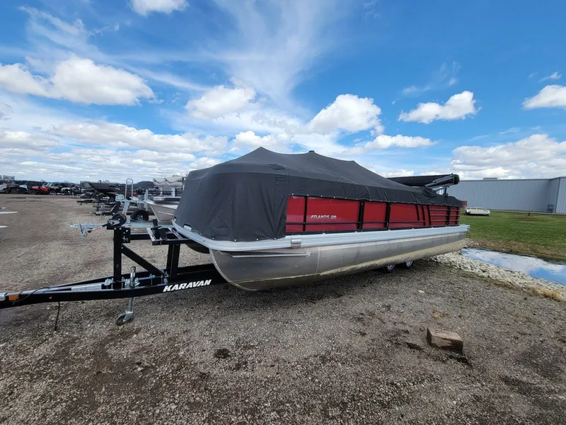 Slide: The Image of 2021 Landau 220 Atlantis pontoon boat with cover on trailer, under a blue sky. - 6