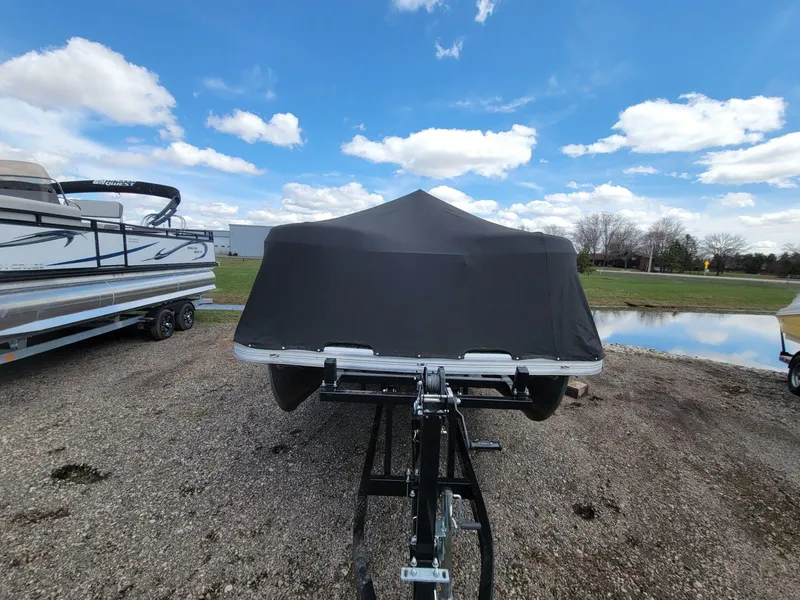 Slide: The Image of 2021 Landau 220 Atlantis boat covered, parked on gravel near a pond under a blue sky. - 7