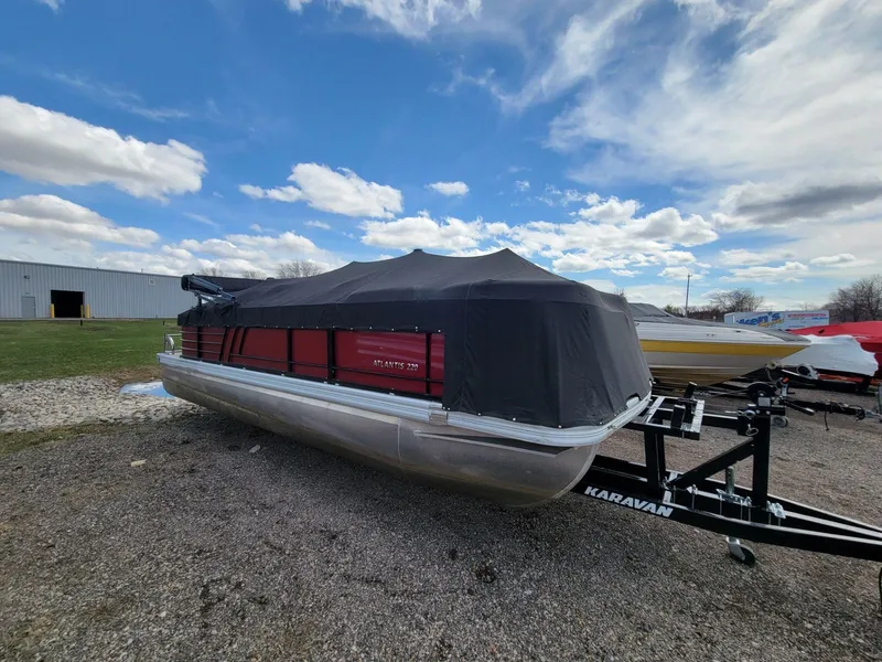 Slide: The Image of 2021 Landau 220 Atlantis pontoon boat covered, on a trailer, under a cloudy sky. - 8
