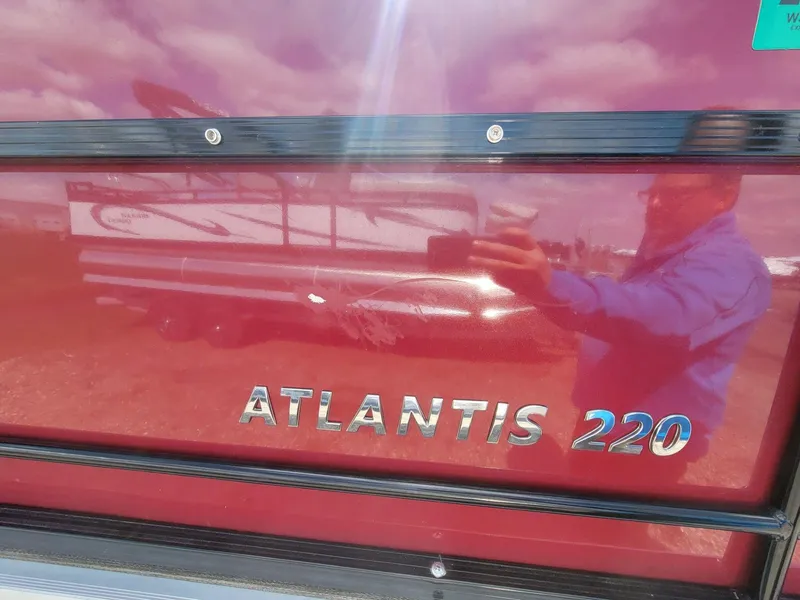 Slide: The Image of 2021 Landau 220 Atlantis boat with reflective red surface and logo. - 9