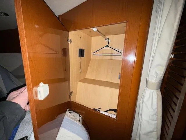 Slide: The Image of 2009 Sea Ray 350 Sundancer cabin closet with wooden interior and hanging space. - 16