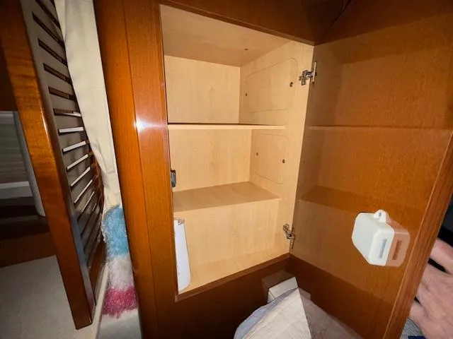 Slide: The Image of Open wooden cabinet inside 2009 Sea Ray 350 Sundancer boat, showcasing interior shelving. - 17
