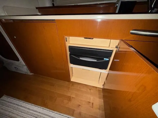 Slide: The Image of 2009 Sea Ray 350 Sundancer interior with wooden cabinetry and built-in storage. - 24