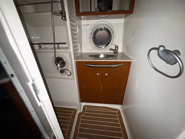 Slide: The Image of 2009 Sea Ray 350 Sundancer bathroom with sink, shower, and wooden cabinetry. - 29
