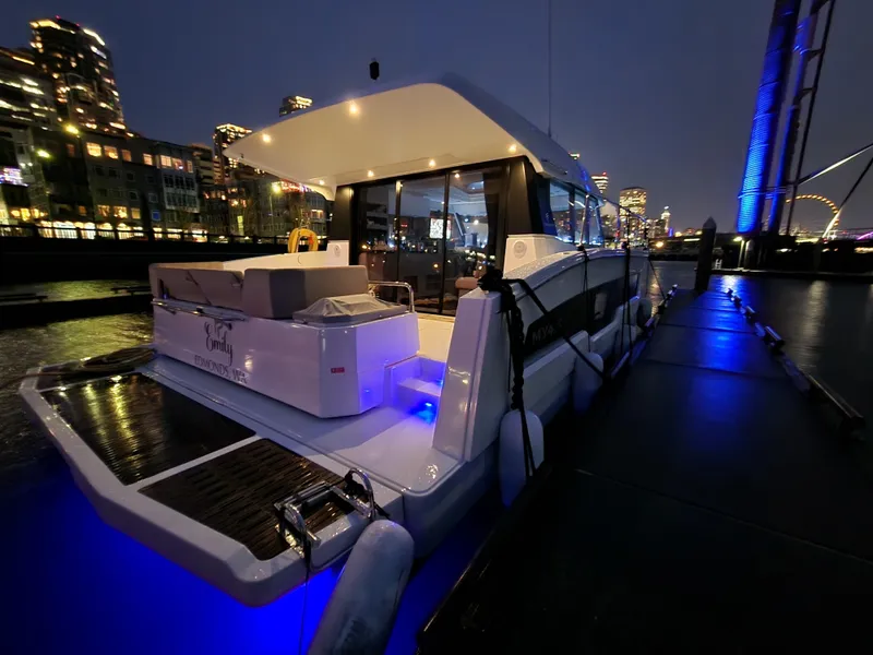 Slide: The Image of 2022 Fountaine Pajot MY4.S yacht docked at night with city lights in the background. - 1