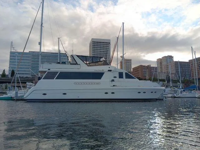 Slide: The Image of 1993 Kha Shing Motoryacht docked in urban marina with city skyline backdrop. - 0