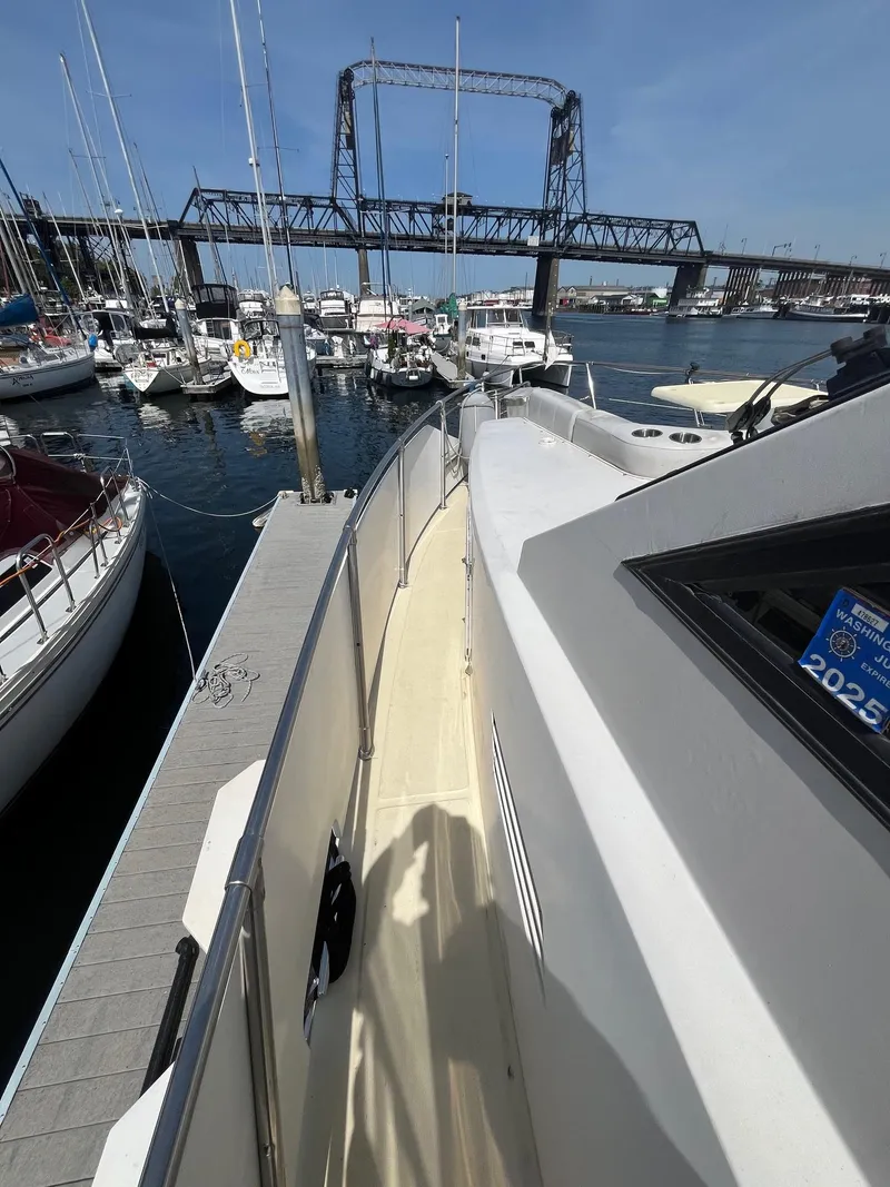 Slide: The Image of 1993 Kha Shing Motoryacht docked at marina with bridge and sailboats in background. - 10