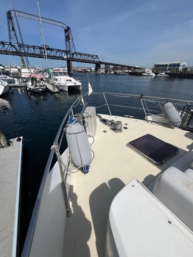 Slide: The Image of 1993 Kha Shing Motoryacht docked near a bridge, surrounded by other boats. - 11