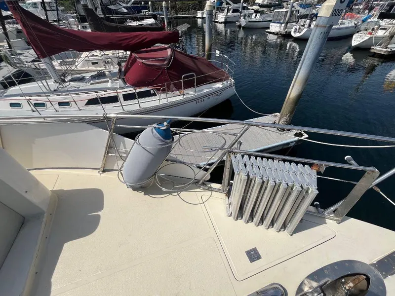 Slide: The Image of 1993 Kha Shing Motoryacht docked, featuring deck view with nearby sailboats in marina. - 12