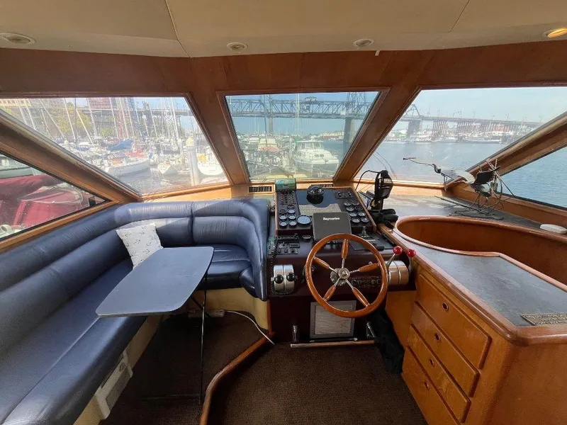 Slide: The Image of Interior of 1993 Kha Shing Motoryacht with helm, seating, and marina view. - 21