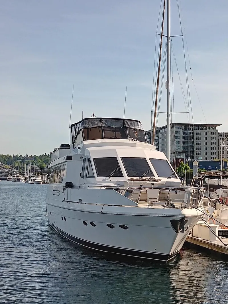 Slide: The Image of 1993 Kha Shing Motoryacht docked in a marina, surrounded by water and buildings. - 3