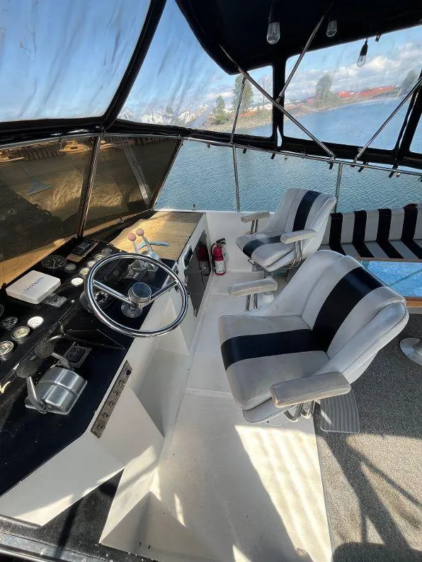 Slide: The Image of 1993 Kha Shing Motoryacht helm with dual seats, overlooking serene waters. - 39