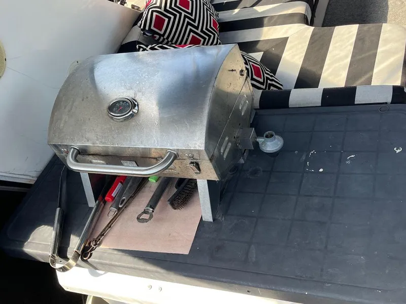 Slide: The Image of Portable grill on a Kha Shing Motoryacht, 1993, with striped cushions and grilling tools. - 47