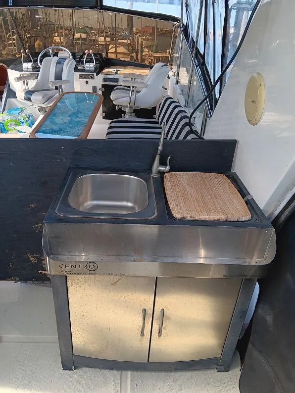 Slide: The Image of Outdoor sink and counter on 1993 Kha Shing Motoryacht with striped seating in background. - 48