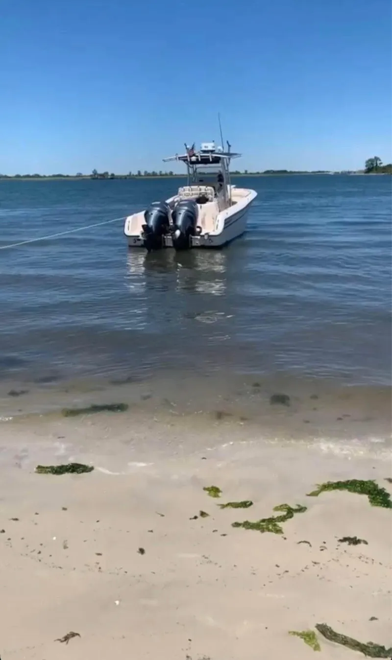 Slide: The Image of 2005 Grady-White Release 283 boat anchored near sandy shore on a sunny day. - 2