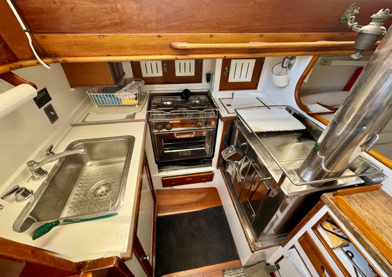 Slide: The Image of Interior of a 1956 Aage Nielsen 50' Yawl, featuring wooden cabinetry and seating. - 18