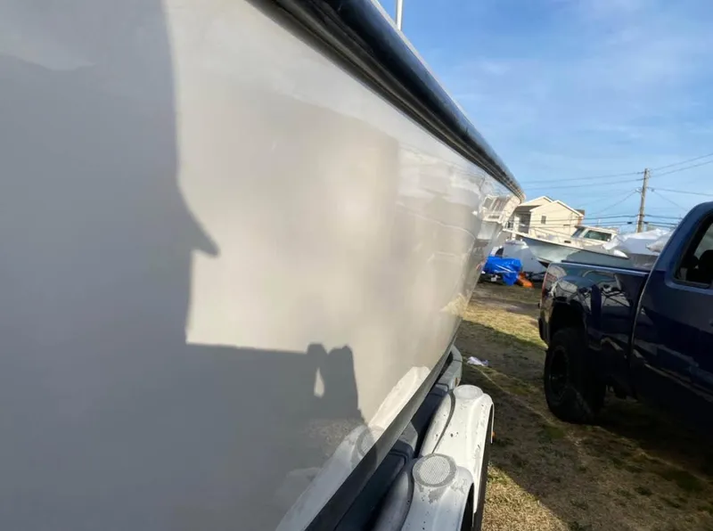 Slide: The Image of 1998 Albemarle 242 Center Console boat on trailer, side view with clear sky background. - 9