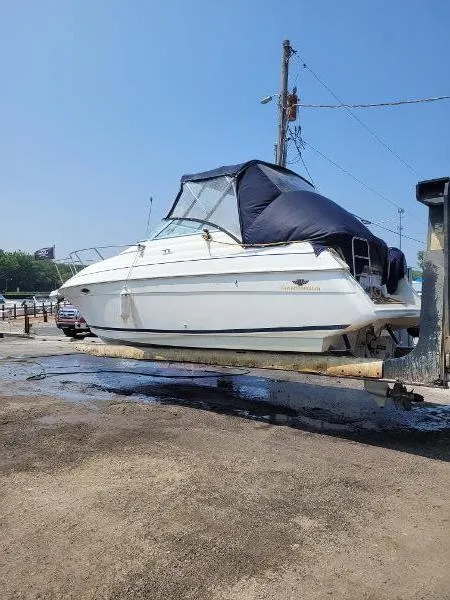 Slide: The Image of 1995 Wellcraft 2400 Martinique boat on trailer, covered, outdoors on a sunny day. - 4
