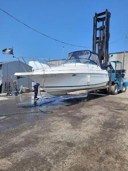 Slide: The Image of 1995 Wellcraft 2400 Martinique boat lifted by forklift for maintenance. - 5