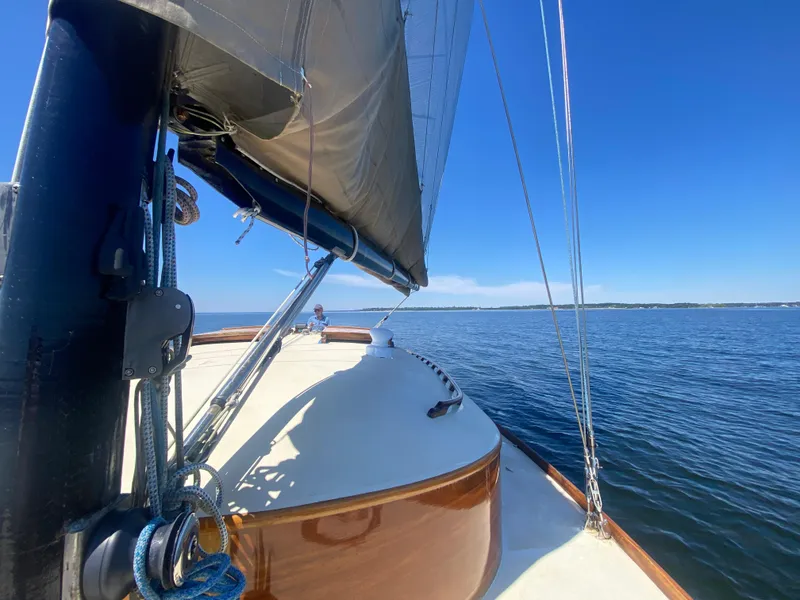 Slide: The Image of 37ft Catboat Yacht sailing on calm waters under clear blue skies. - 10