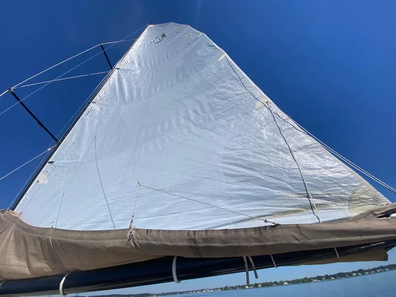 Slide: The Image of Sail of a 2012 Custom 37ft Catboat Yacht against a clear blue sky. - 11