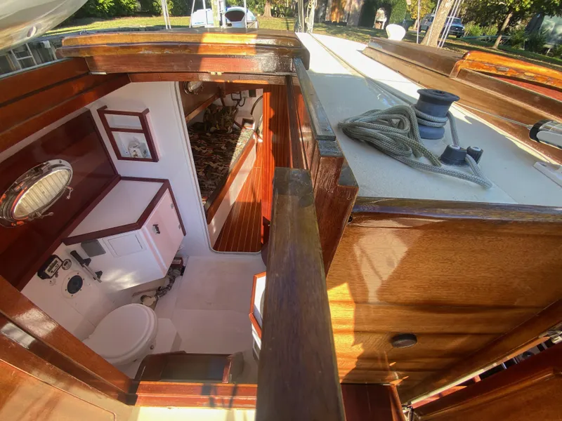 Slide: The Image of Interior view of a 2012 custom 37ft Catboat Yacht, featuring wooden finishes and nautical equipment. - 18