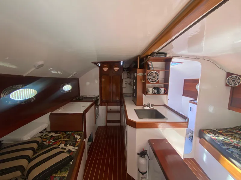Slide: The Image of Interior of 2012 Custom 37ft Catboat Yacht with wood accents and compact kitchen area. - 19