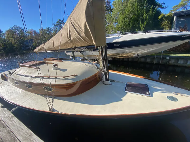 Slide: The Image of 37ft custom catboat yacht, Barnegat Bay A-Cat, docked by a serene waterfront, 2012 model. - 26