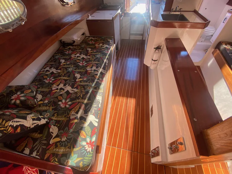 Slide: The Image of Interior of 2012 Custom 37ft Catboat Yacht with floral bedding and wooden flooring. - 39