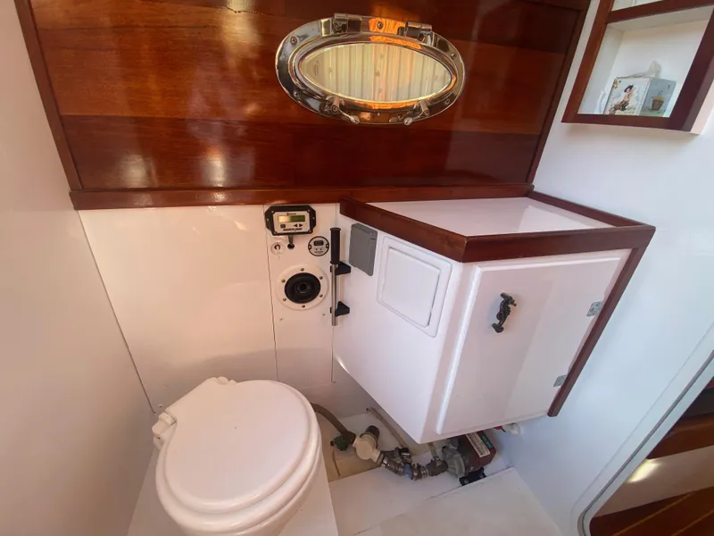 Slide: The Image of Luxurious yacht bathroom with wooden accents, featuring a toilet and storage cabinet. - 44
