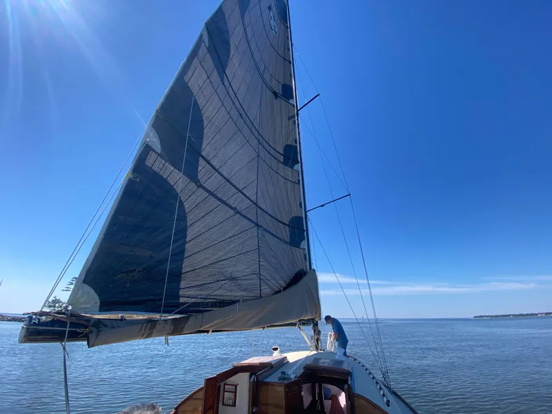 Slide: The Image of 37ft Custom Catboat Yacht sailing on calm waters under a clear blue sky. - 8