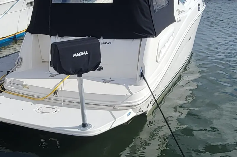 Slide: The Image of 2006 Sea Ray 260 Sundancer boat docked with Magma grill on the swim platform. - 12
