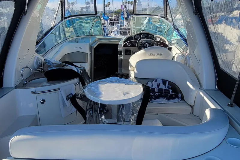 Slide: The Image of 2006 Sea Ray 260 Sundancer interior with seating and helm, showcasing luxury boat design. - 13