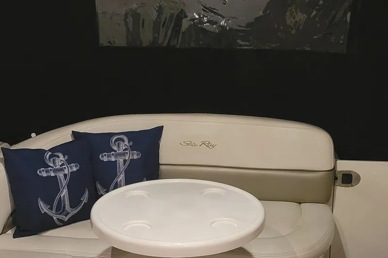 Slide: The Image of 2006 Sea Ray 260 Sundancer interior with anchor-themed cushions and round table. - 15