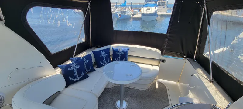 Slide: The Image of Interior of 2006 Sea Ray 260 Sundancer with seating, table, and nautical-themed pillows. - 6