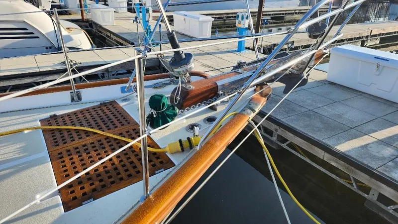 Slide: The Image of 1989 Cabo Rico 34 sailboat docked, featuring wooden deck and rigging details. - 11