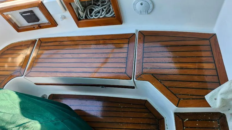 Slide: The Image of 1989 Cabo Rico 34 sailboat cockpit with polished wooden seating and storage compartments. - 22